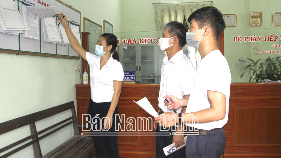 Cán bộ phụ trách bộ phận một cửa thị trấn Gôi (Vụ Bản) hướng dẫn người dân quy trình giải quyết thủ tục hành chính.