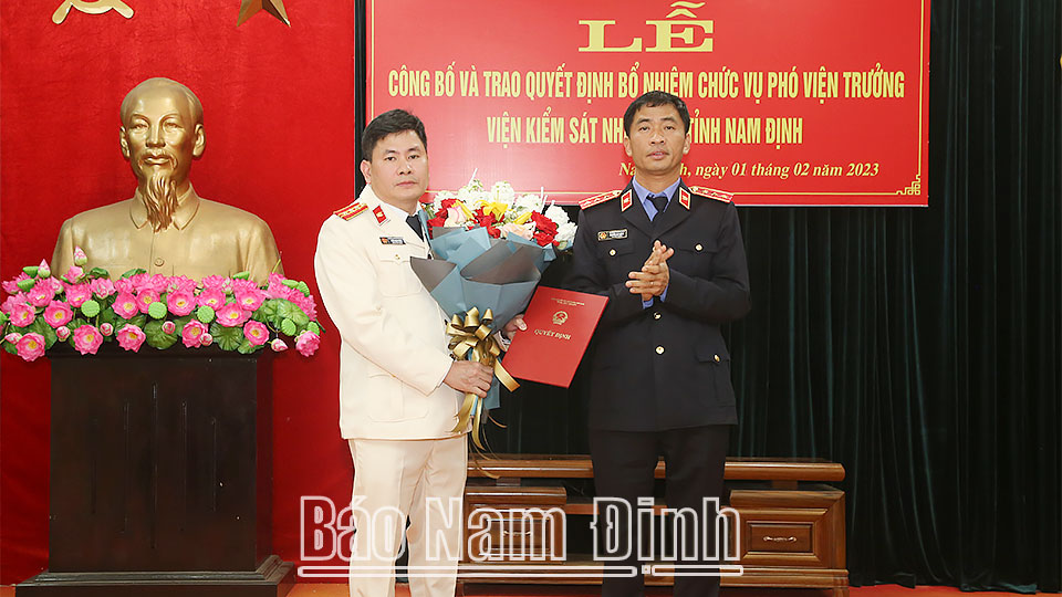 Đồng chí Nguyễn Duy Giảng, Phó Viện trưởng Viện KSND tối cao trao Quyết định và tặng hoa chúc mừng đồng chí Trần Mạnh Đông